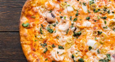 Tahta masada pizza var. Restoran ve pizzacılar için konsept promosyon şablonu. Yemek malzemeleri ve baharatlı geleneksel İtalyan pizzası. Uzayı kopyala Üst Manzara. Pankart. Pizza menüsü.