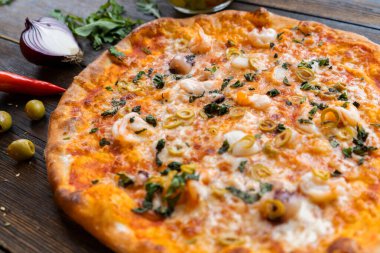 Tahta masada pizza var. Restoran ve pizzacılar için konsept promosyon şablonu. Yemek malzemeleri ve baharatlı geleneksel İtalyan pizzası. Uzayı kopyala Üst Manzara. Pankart. Pizza menüsü.