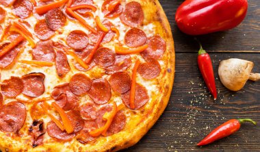 Tahta masada pizza var. Restoran ve pizzacılar için konsept promosyon şablonu. Yemek malzemeleri ve baharatlı geleneksel İtalyan pizzası. Uzayı kopyala Üst Manzara. Pankart. Pizza menüsü.