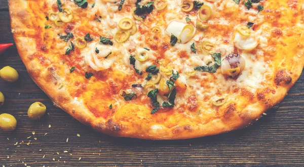 Tahta masada pizza var. Restoran ve pizzacılar için konsept promosyon şablonu. Yemek malzemeleri ve baharatlı geleneksel İtalyan pizzası. Uzayı kopyala Üst Manzara. Pankart. Pizza menüsü.