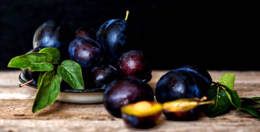 Köy arka planında yeşil yapraklı olgun erik. Olgun taze organik erikler..