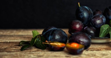 Köy arka planında yeşil yapraklı olgun erik. Olgun taze organik erikler..