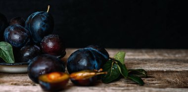 Köy arka planında yeşil yapraklı olgun erik. Olgun taze organik erikler..