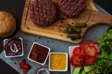 A set of different ingredients for making a burger. Cooking a burger. Homemade hambrger. Top view with free space for your text.