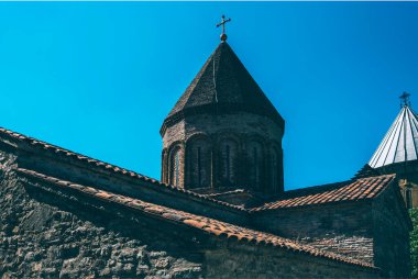 Medieval castle complex with church on Jinvali water reservoir, Aragvi river, Ananuri, Georgia. Grainy filter toned with a retro vintage effect.