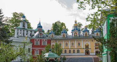 View of beautiful buildings and orthodox churches ancient Pskov-Pechersky monastery. Fortress wall and tower. Pechory, Pskov, Russia.