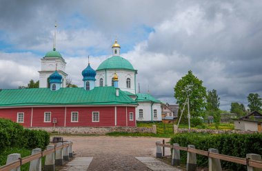 View of beautiful buildings and orthodox churches ancient Pskov-Pechersky monastery. Fortress wall and tower. Pechory, Pskov, Russia.