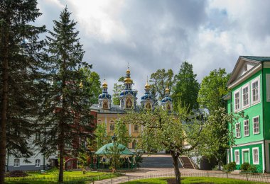 View of beautiful buildings and orthodox churches ancient Pskov-Pechersky monastery. Fortress wall and tower. Pechory, Pskov, Russia.