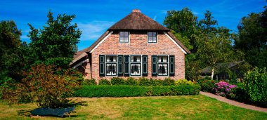 Hollanda, Giethoorn 'un tipik evleri. Güzel evler ve bahçıvanlık. Çiftlik alanındaki ünlü Giethoorn köyünün manzarası. Kanalları ve sazdan yapılmış çatıları var..