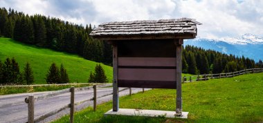 Mock up wooden board advertising. Billboard at the mountain rural road. Old wooden background display your product insert text. Retro vintage decoration style. Blank billboard for advertisement.