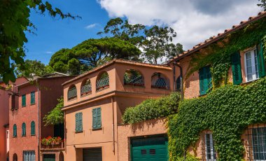 Eco architecture with plants and flowers on the facade. Ecology and green environment concept. Colorful mediterranean buildings in spectacular resort, Liguria, Italy, Europe. Picturesque town street view.