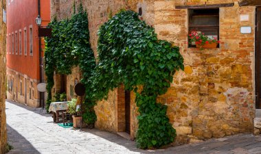 View of old cozy street in medieval town. Architecture and landmark of Italy. The picturesque narrow street and the ancient architecture of San Gimignano, Tuscany, Italy.