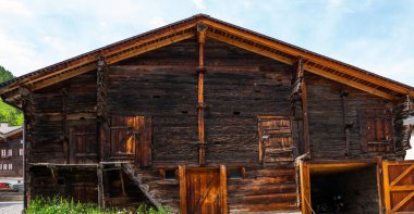 Yıpranmış eski ahşap doku arka planı. İsviçre Alpleri 'ndeki köyde ahşap cephe evi. Ahırlar, dükkanlar, ahırlar ve eski evler. Tahta ahşap duvar dokusu arkaplanı.