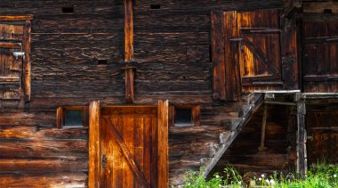 Yıpranmış eski ahşap doku arka planı. İsviçre Alpleri 'ndeki köyde ahşap cephe evi. Ahırlar, dükkanlar, ahırlar ve eski evler. Tahta ahşap duvar dokusu arkaplanı.
