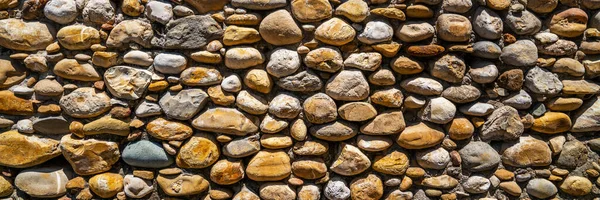 Vintage stone wall. Old castle wall texture as a background or texture. Decorative uneven cracked real stone wall surface.