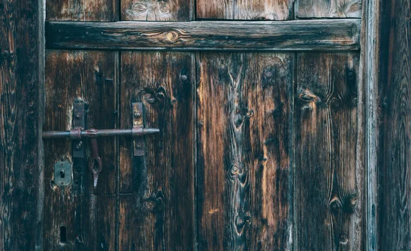 用钢制铰链的旧风化木门 沮丧的小组 旧墙体纹理背景 带有生锈门闩的旧木门的细部 — 图库照片