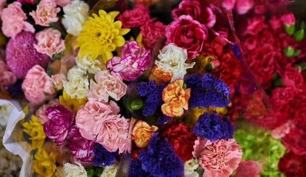 Beautiful bouquets of mixed flowers in a flower shop. A bright mix of flowers. Background on full screen. Handsome fresh bouquets. Flowers delivery. Floral shop concept .