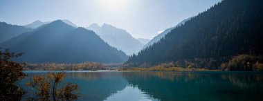Seçici odaklanma. Dağlardaki dinginlik gölü. Dağlar ve yansıma ile sisli bir sonbahar sabahı.