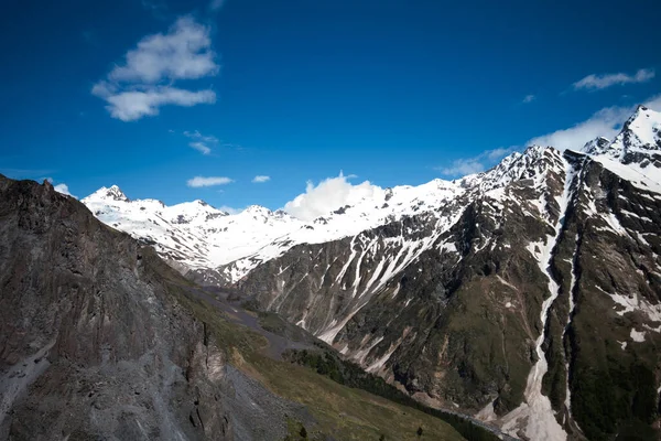 Dağ zirveleri karla kaplı mavi parlak gökyüzünün altında güzel bulutlar. Dünyanın güzel yerlerini keşfetmek için. Doğal manzara..