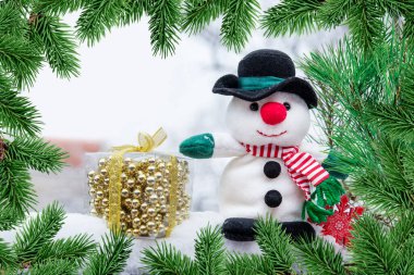 Yeni yıl ve Noel konsepti. Mutlu noeller. Bir kardan adam ve köknar dallı bir çerçeve içinde hediye.