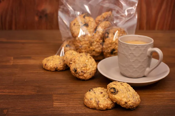 Ev yapımı tahıllı kurabiyeler, yulaf ezmesi, kuru üzüm, fındık, kahverengi ahşap arka planda tohumlar. Sağlıklı gıda konsepti. Boşluğu kopyala.