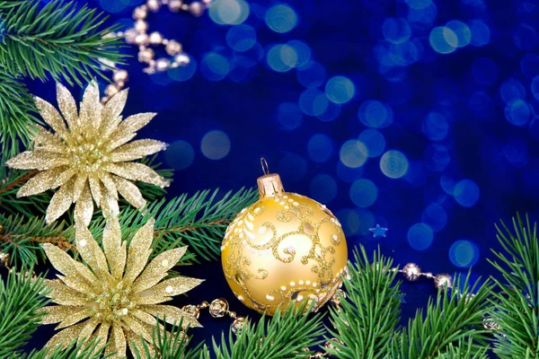 Yeni yıl kompozisyonu. Bokeh 'li mavi arka plan, köknar dalları ve altın top süslemeleri Noel, kış, yeni yıl konsepti. Boşluğu kopyala
