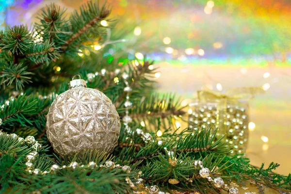 Güzel bir kozalaklı dalın kompozisyonu ve altın bir arka planda Noel ağacı süslemesi. Yeni yıl konsepti