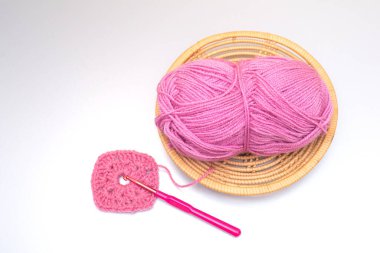 Örgü örmek için iplik. İplik kesesi, tığ işi kancası, gri arka planda yakın plan. Üst görünüm, dikiş konsepti. Boşluğu kopyala.