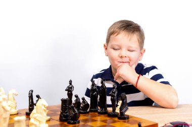 Küçük bir çocuk satranç oynuyor. Çocuk satrancı. Beyaz arka plan. Kopyalanacak yer.