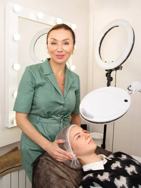 Bir kozmetolog akne tedavisi, beslenme ve vitamin terapisi için bir prosedür uygular. Estetik kozmetoloji. Genç sivilceler.