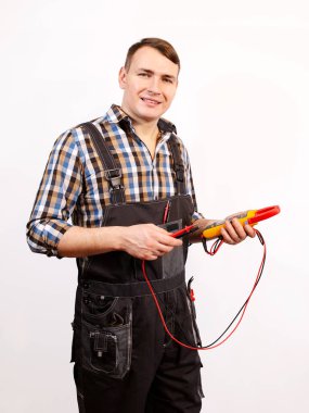 DIY (DIY) ev yenileme konsepti. Üniformalı bir elektrikçi elinde bir cihaz tutuyor. Yakın plan..