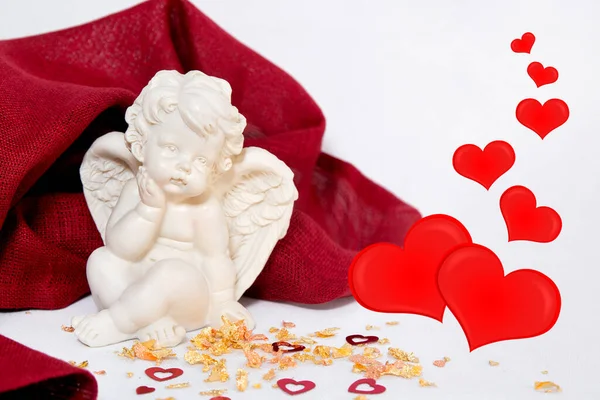 Sevgililer Günü. Beyaz arka plandaki melek kırmızı bir bez, kalpli altın tozu..