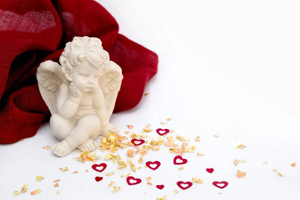 Sevgililer Günü. Beyaz arka plandaki melek kırmızı bir bez, kalpli altın tozu.
