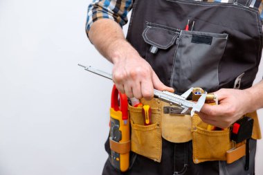 Bir işçi bir parçanın boyutunu ölçer. Caliper elinde. Yakın plan..