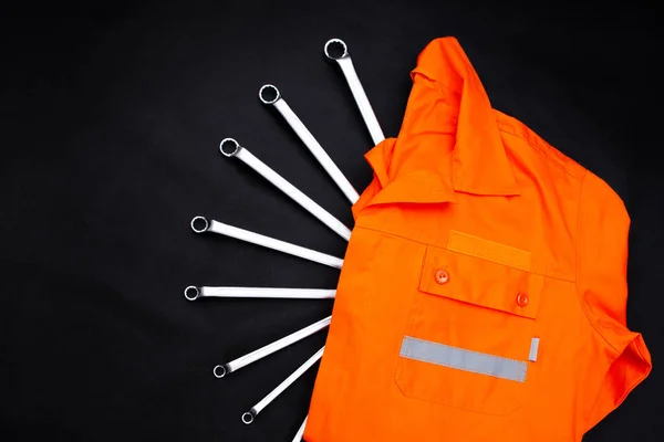 Tamirci için üniforma ve aletler. Siyah arkaplan.