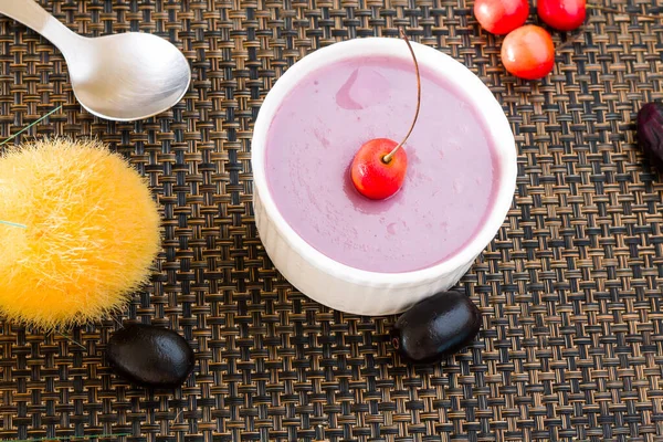 Jamun Mousse,Java Plum or Black Plum Mousse.Fresh,homemade,healthy vegan dessert made from Jamun or Indian Blackberry or Malabar Plum.Topped with cherry,isolated on dark background.Closeup,top view,text space of summer dessert or souffle.