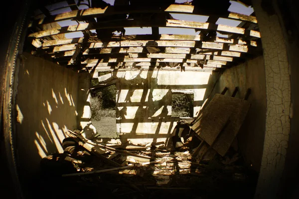 Olho de peixe tiro de um quarto dilapidado marrom em um edifício abandonado onde a luz solar filtra através do telhado exposto — Fotografia de Stock