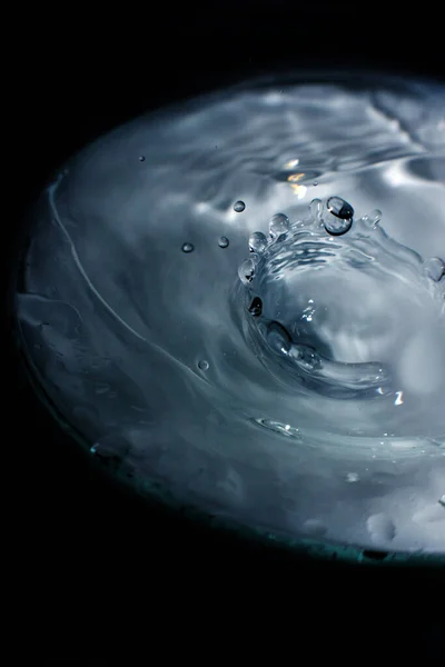 Wasser plätschert in einem Pool mit schwarzem Hintergrund — Stockfoto