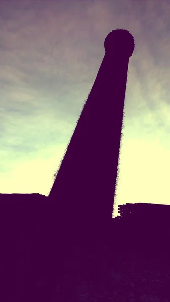Högt torn siluett mot en ljus himmel — Stockfoto