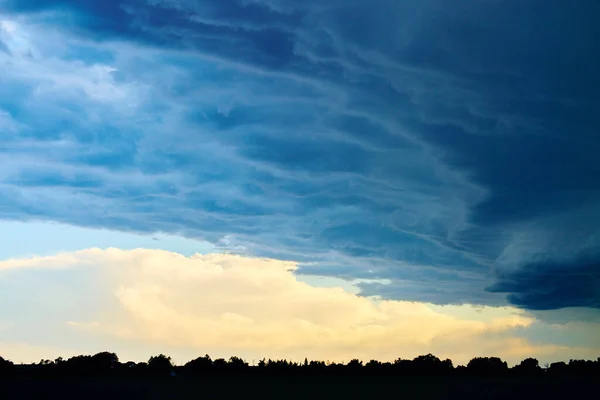 森や農地のシルエットの上に大きな嵐の雲 — ストック写真