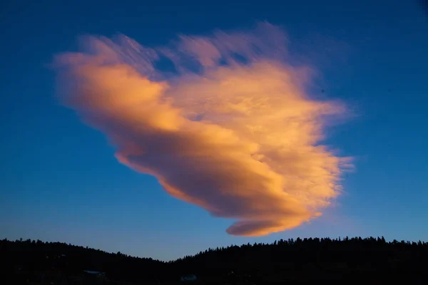 山のシルエットの青い空に大きなピンクと白の雲 — ストック写真