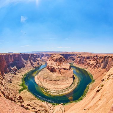 Büyük bir nehri çevreleyen bir kanyonun ya da kayalık bir at nalı kıvrımının etrafındaki göletin havadan çekilmiş görüntüsü.
