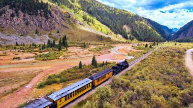 Dağlarla çevrili vadiden geçen kömürlü eski siyah tren.