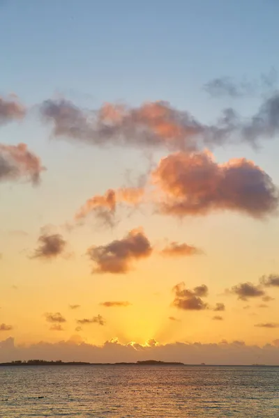 Nascer do sol em trópicos com céu dourado e nuvens rosa — Fotografia de Stock