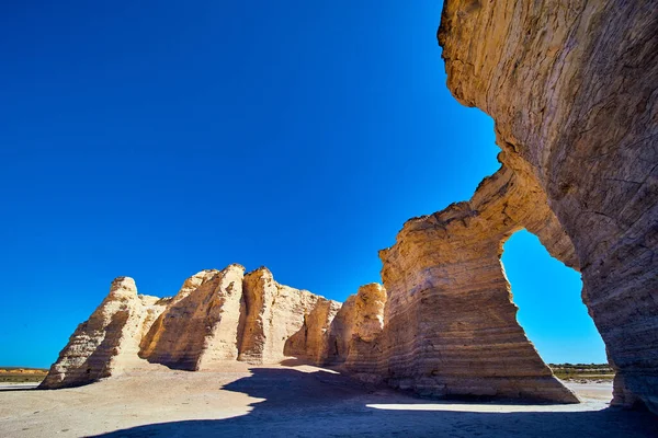 Pijlers van witte rots in vlakke woestijn met levendige blauwe lucht — Stockfoto