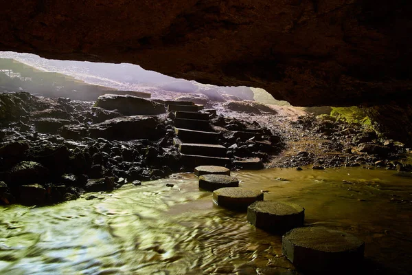 Steps in cave over river — Stock Photo, Image