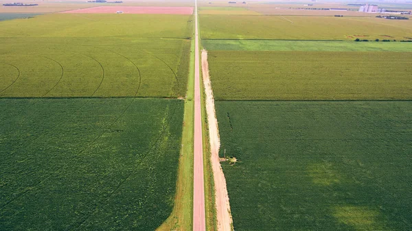 Antenne lange gerade Straße, die über Felder von Ackerland schneidet — Stockfoto