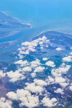 Küçük beyaz bulutlu ve mavi sulu uçak manzaralı.