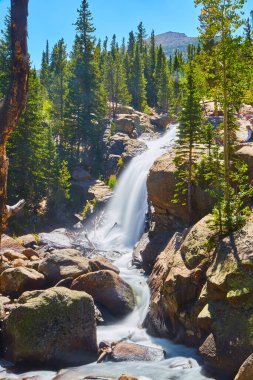 Dağlardaki kayaların üzerindeki büyük şelalenin dikey görünümü