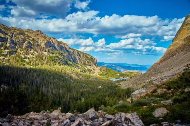 Çam ağaçlarıyla çevrili kayalık dağlarda göl